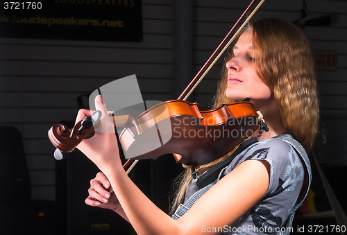 Image of Attractive woman plays on violin