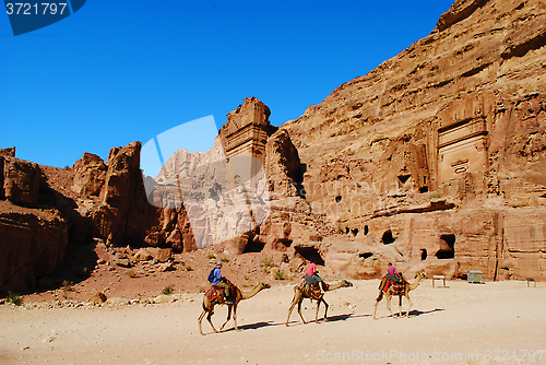 Image of Tourists passing the Uneishu Tomb on the Street of Facades in Petra, Jordan