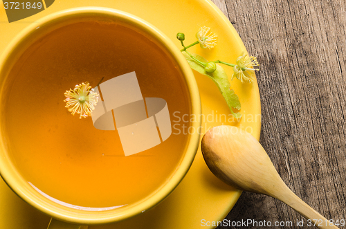 Image of Yellow cup with linden tea on the table,  top view