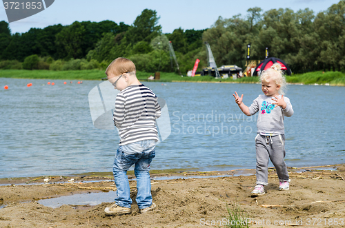 Image of  Boy and girl playing in the sand on the shore of Lake 