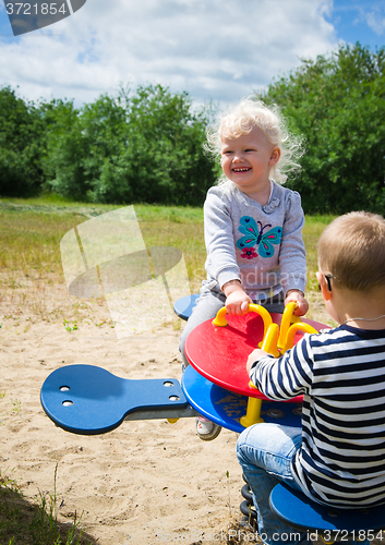 Image of Boy and girl swinging on a swing