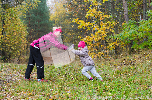 Image of Woman with girl doing aerobics in the autumn park