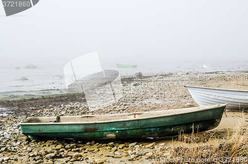 Image of Old fishing boat at coast foggy in the morning