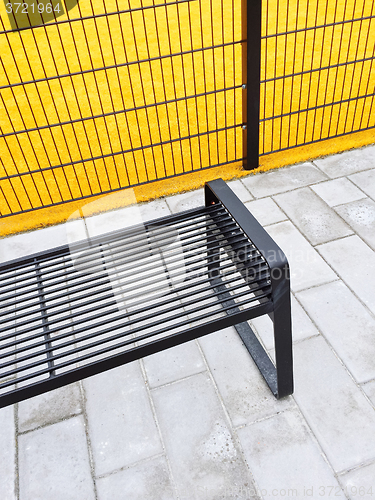 Image of Metal bench near bright yellow playground