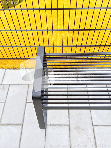 Image of Bright yellow playground and metal bench