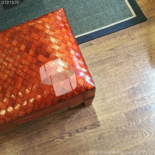 Image of Orange leather bench on wooden floor