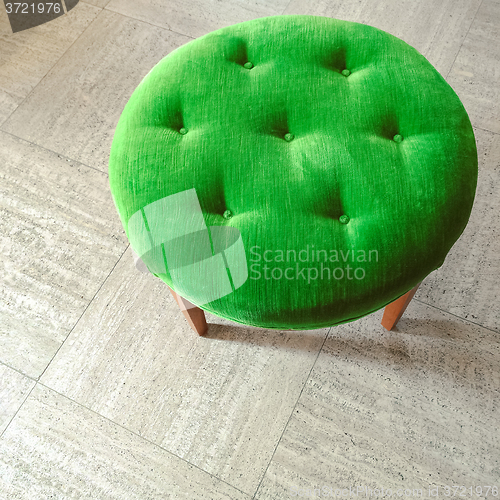 Image of Green velvet stool on tiled floor