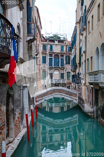 Image of Narrow canal with bridge in Venice