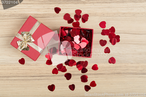 Image of Red hearts confetti on wooden background