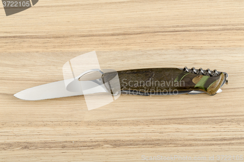 Image of Multipurpose knife on wooden background