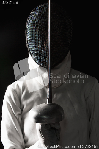 Image of The portrait of woman wearing white fencing costume  on black 