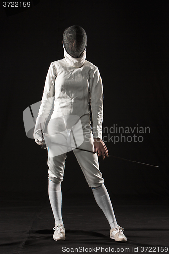 Image of The portrait of woman wearing white fencing costume  on black 