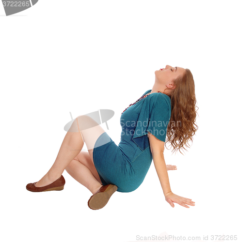 Image of Woman in dress sitting on floor.
