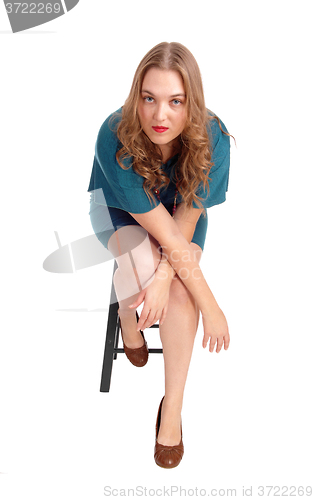 Image of Woman sitting on chair bend forwards.