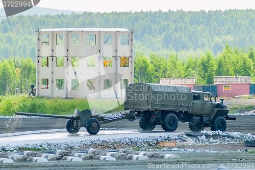 Image of army truck transports gun after water ford