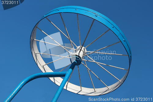 Image of Metal detail as a bicycle wheel against the sky