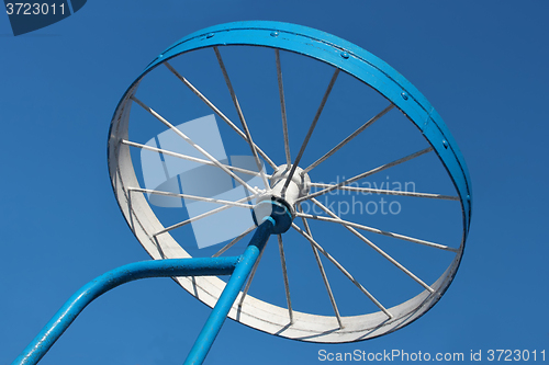 Image of Metal detail as a bicycle wheel against the sky