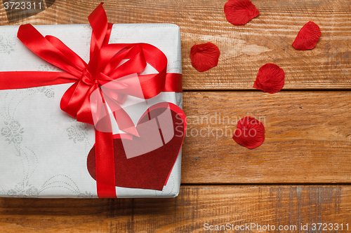 Image of Valentines Day gift and hearts  on wooden background