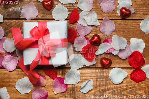 Image of Valentines Day gift and hearts  on wooden background