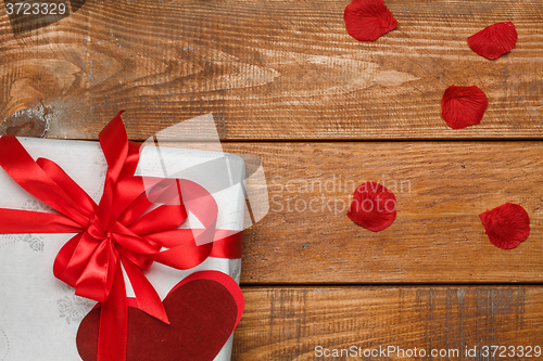 Image of Valentines Day gift and hearts  on wooden background