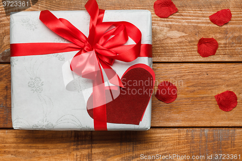 Image of Valentines Day gift and hearts  on wooden background