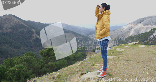 Image of Young woman looking out over mountain scenery