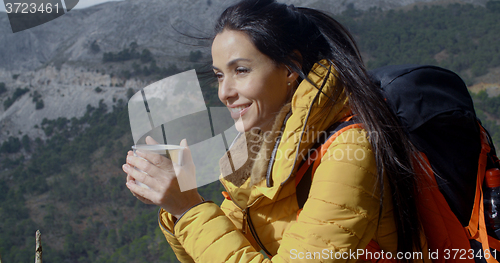 Image of Young woman backpacker enjoying coffee