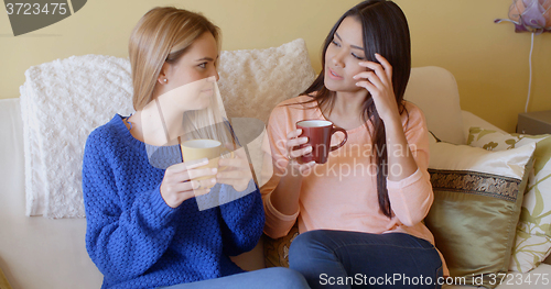 Image of Two pretty young women enjoy a relaxing coffee