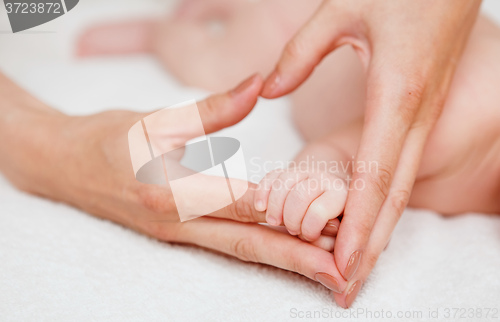 Image of Baby holding mother finger and together form heart shape by hand.