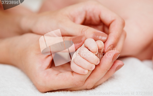 Image of Baby holding mother finger 