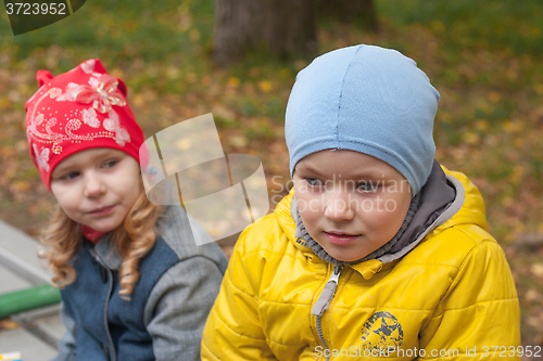 Image of two children in a park in autumn, portrait