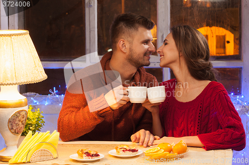 Image of The  happy young couple with cups of tea 