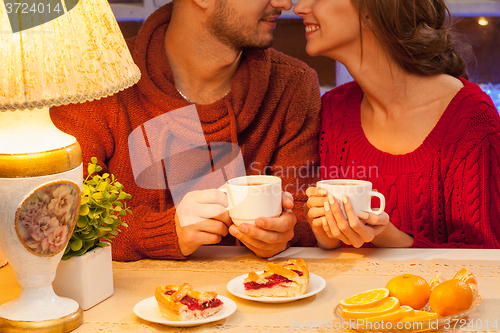 Image of The  happy young couple with cups of tea 