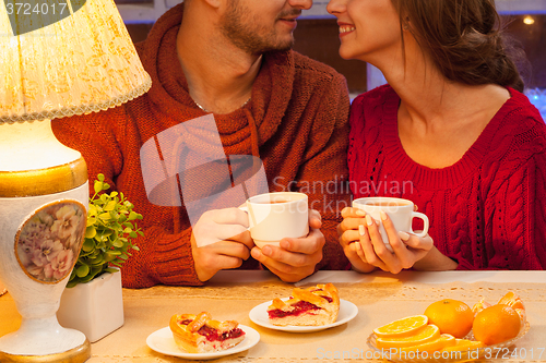 Image of The  happy young couple with cups of tea 