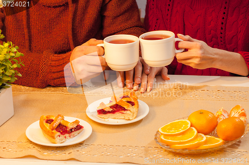 Image of The  happy young couple with cups of tea 