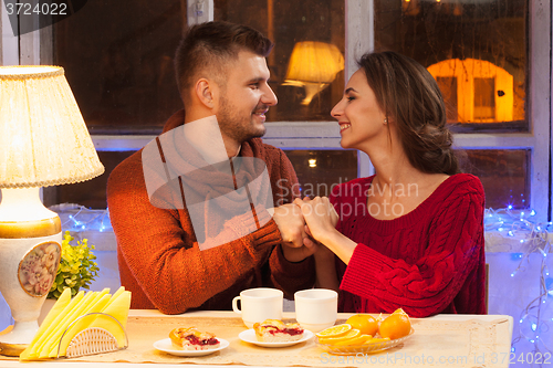 Image of The  happy young couple with cups of tea 
