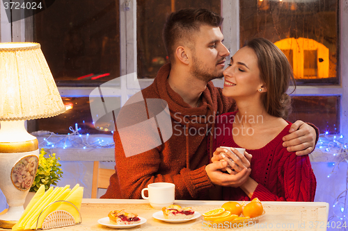 Image of The  happy young couple with cups of tea 