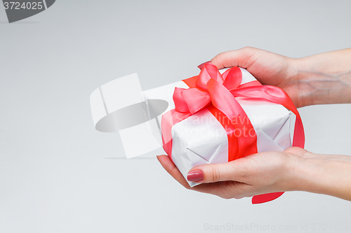 Image of Female hands holding gift box