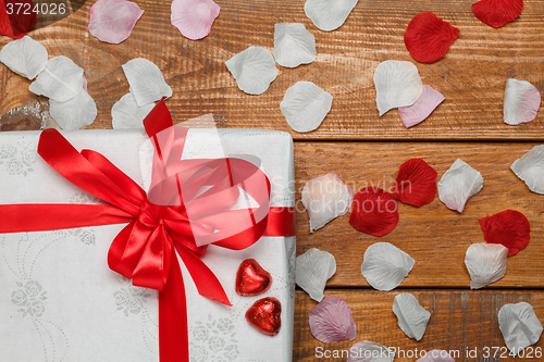 Image of Valentines Day gift and hearts  on wooden background