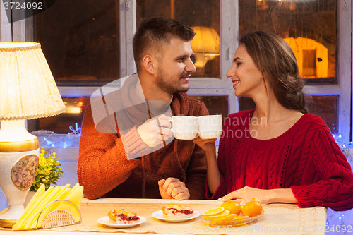 Image of The  happy young couple with cups of tea 