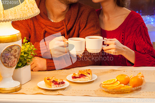 Image of The  happy young couple with cups of tea 