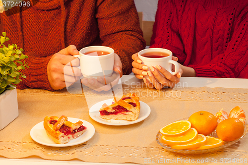 Image of The  happy young couple with cups of tea 