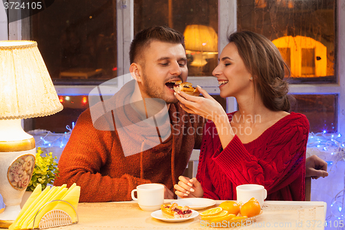 Image of The  happy young couple with cups of tea 