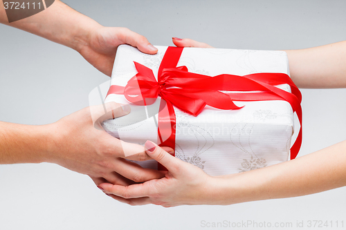 Image of Hands giving and receiving a present