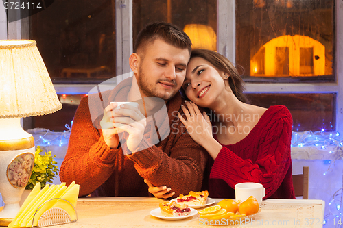 Image of The  happy young couple with cups of tea 