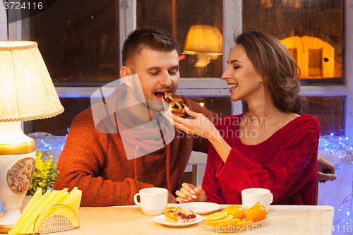 Image of The  happy young couple with cups of tea 