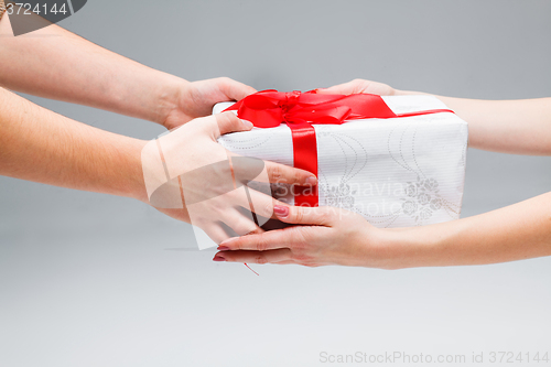 Image of Hands giving and receiving a present