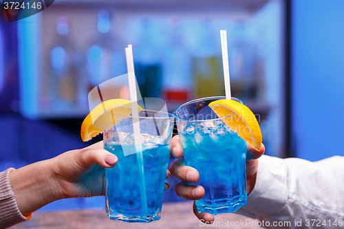 Image of The hands with alcohol cocktails making toast on a bar background