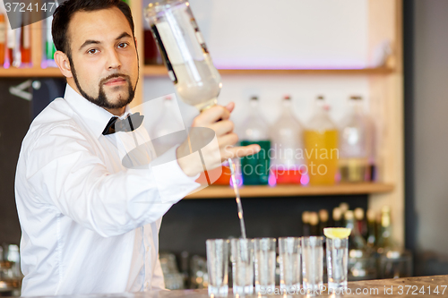 Image of Barman at work, preparing cocktails.