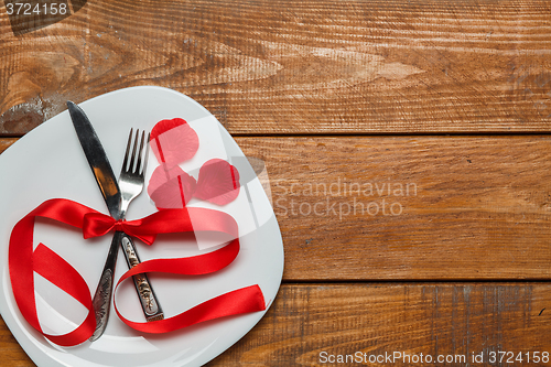 Image of The red ribbon in plate on wooden background